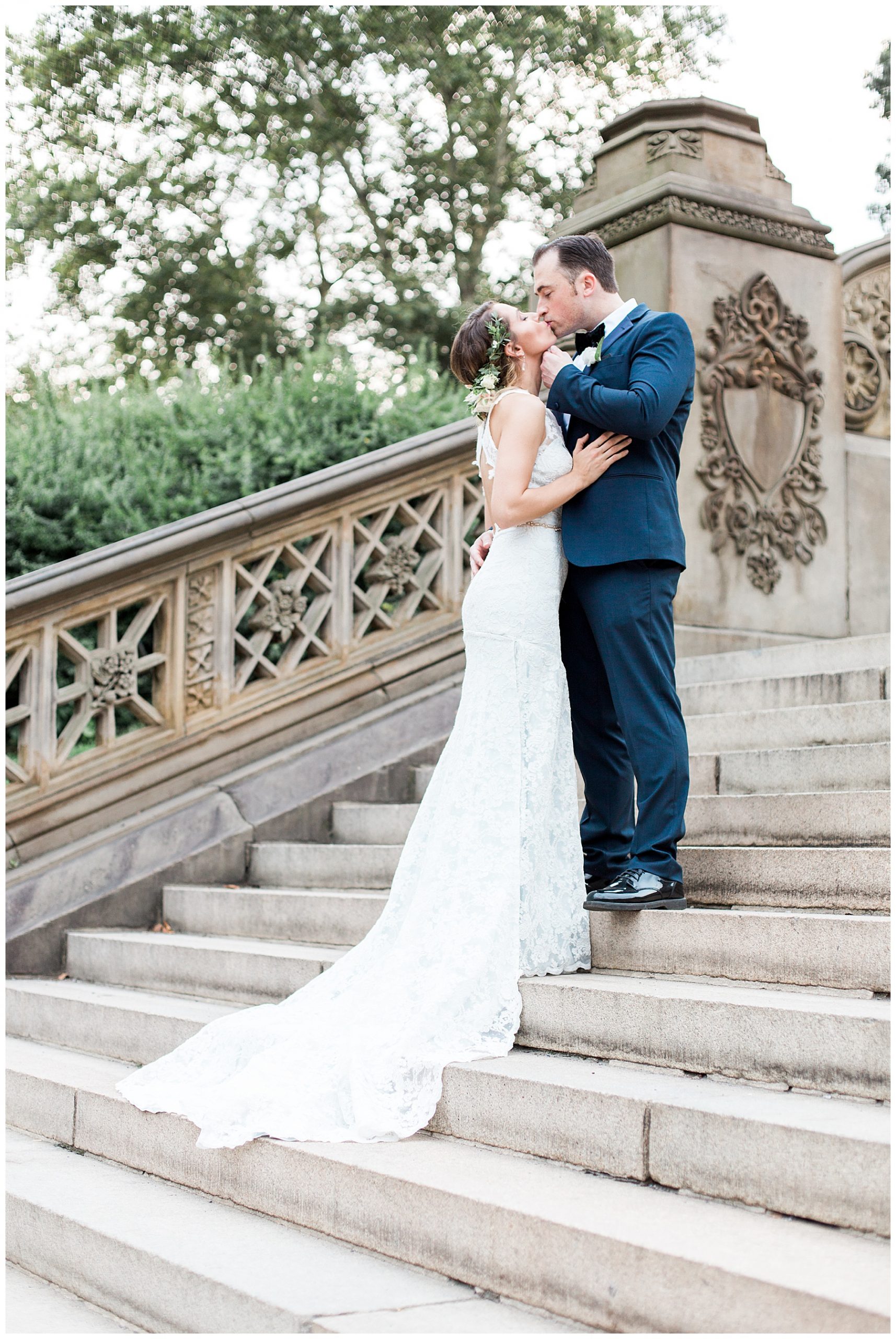 groom kissing bride on steps with bridal train in central park 